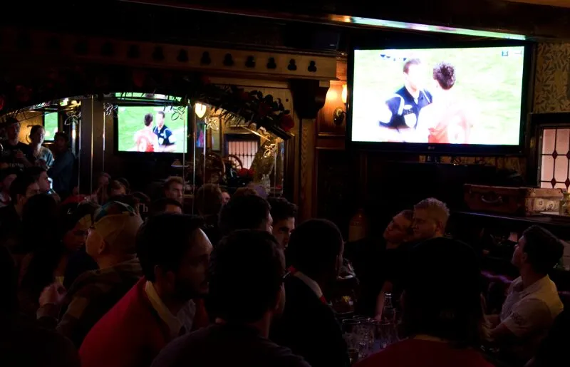 Personer ser på fotballsending inne i sportspuben Highbury i Oslo.